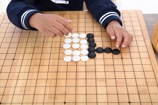 小孩子在棋盤上學習下圍棋