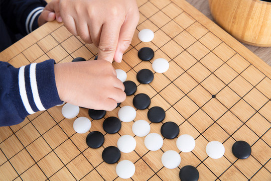 小孩子的手在擺放圍棋棋子