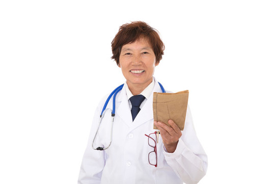 大夫手拿藥書笑著看鏡頭