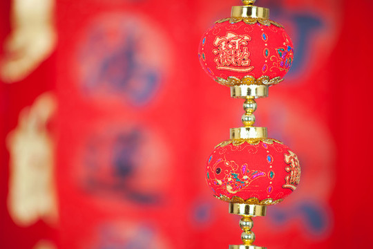 紅色春聯(lián)前掛著一串燈籠飾品
