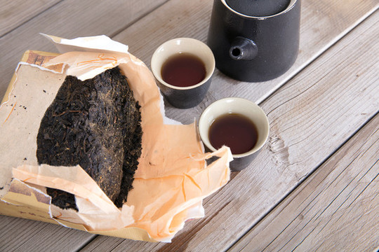 黑磚茶和茶杯茶壺在桌子上