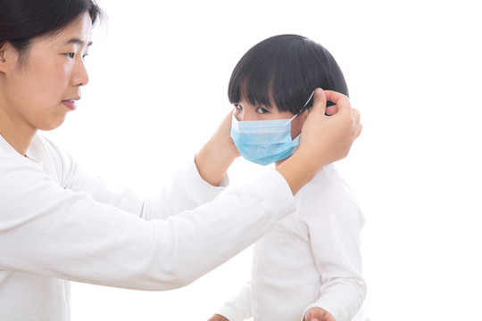 媽媽幫女兒戴上口罩進行防護