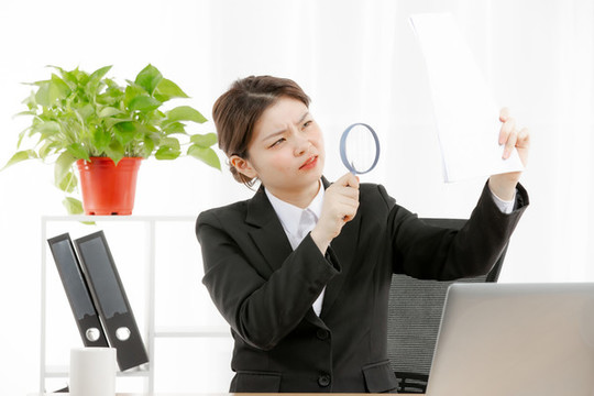 商務女性拿放大鏡看東西