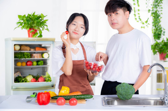 情侶從冰箱里拿蔬菜準(zhǔn)備做飯
