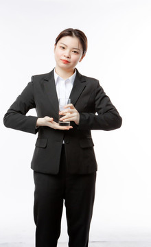 商務(wù)女性拿水杯站著擺拍