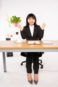 商務(wù)女性在辦公室坐著擺拍