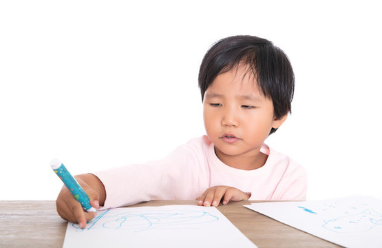 可愛(ài)的黃皮膚小姑娘在認(rèn)真的畫(huà)畫(huà)