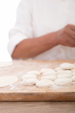 背景里正在包餃子的手
