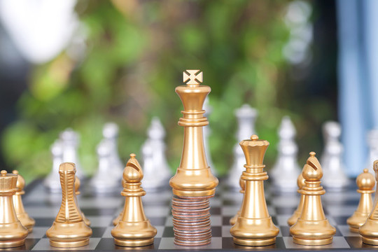金色的國王棋子在一摞硬幣上