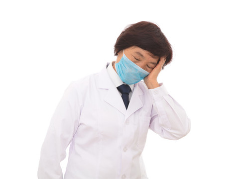 白背景前戴著口罩勞累的女大夫