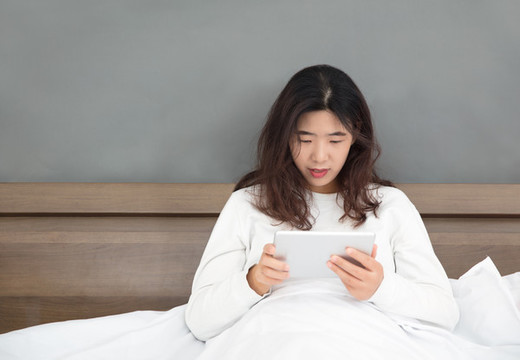 漂亮的東方女性在使用iPad