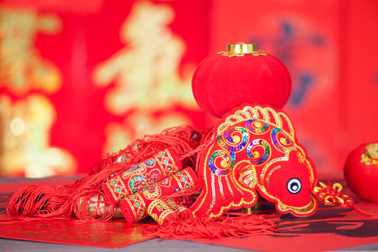 紅色對聯(lián)背景前的年年有余掛飾