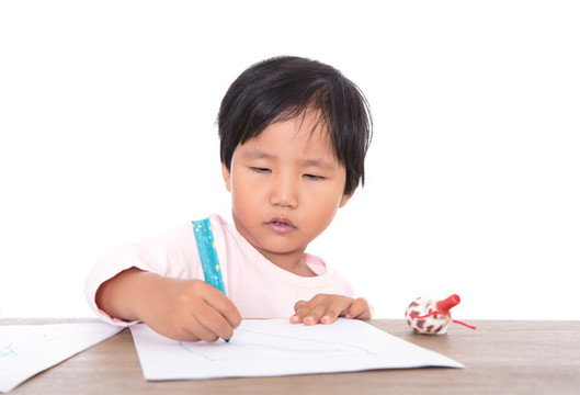 趴在桌子上認真畫畫的小女孩