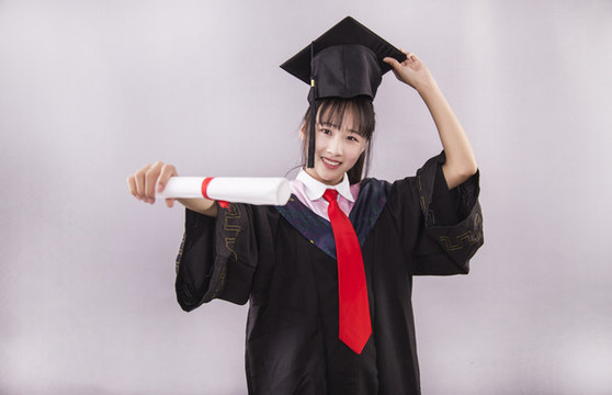 純色背景下穿著學(xué)士服的女孩