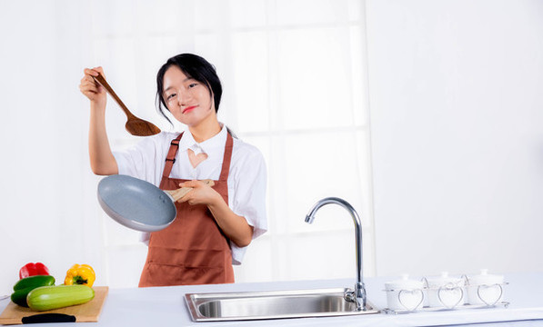 在廚房拿著鍋鏟的年輕女人