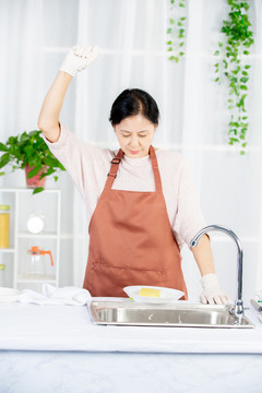 中年女人在廚房清潔餐具