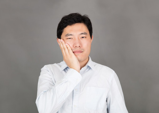 牙疼捂著臉的年輕男士