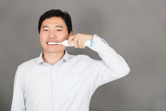 年輕男士用電動(dòng)牙刷刷牙