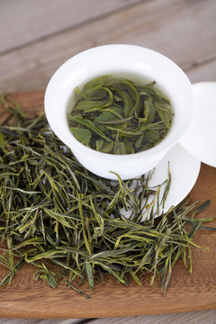 綠茶茶葉和蓋碗里泡好的茶湯