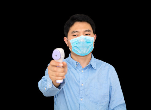 戴口罩的男士手拿紅外體溫計