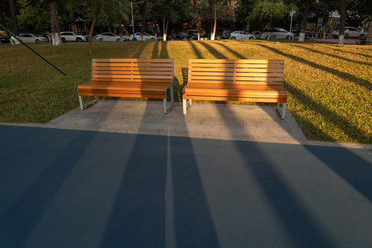 夕陽中橙黃色的公園木質(zhì)長椅