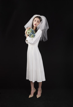 穿著白色連衣裙戴著頭紗的女性