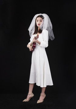 穿著白色連衣裙戴著頭紗的女性