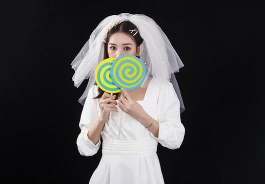穿著白色連衣裙和頭紗的女性