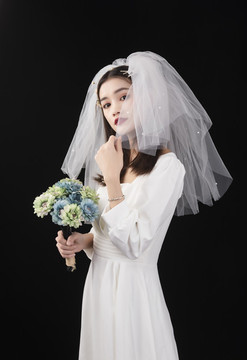 穿著白色連衣裙和頭紗的女性