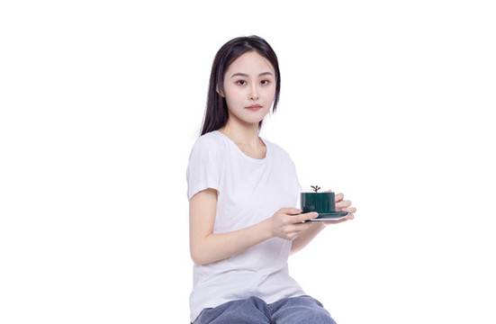 年輕的女性端著咖啡杯