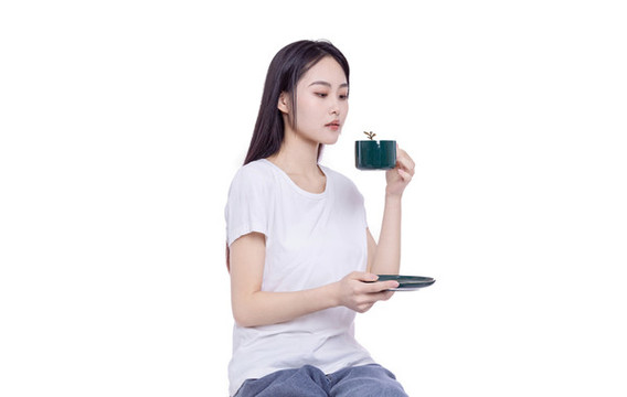 年輕的女性端著咖啡杯