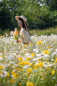 花叢里戴草帽的美女
