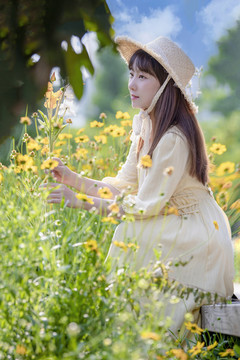 花叢里戴草帽的美女