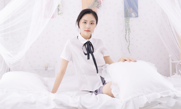 在床上玩手機的年輕女性