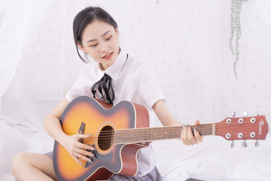 室內女性在床上彈吉他