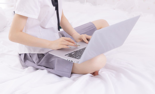 女孩在床上使用筆記本電腦