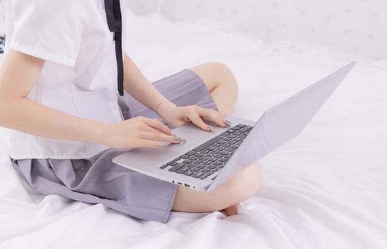 女孩在床上使用筆記本電腦