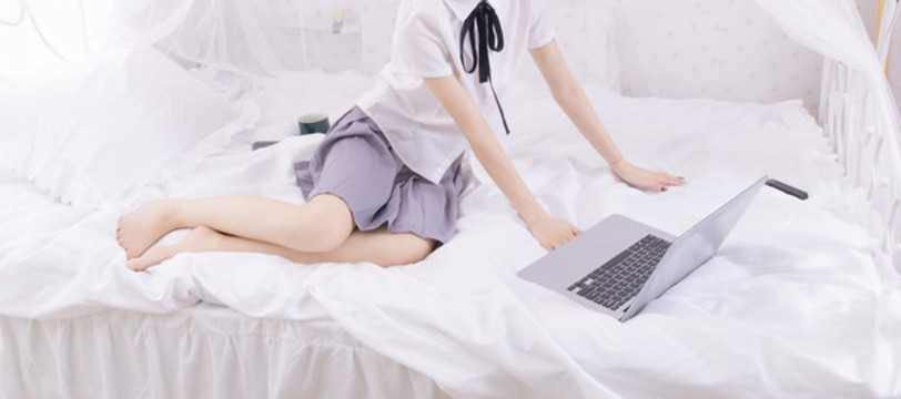 女孩在床上使用筆記本電腦