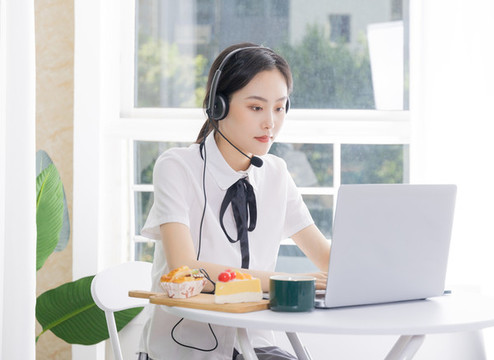 女性客服戴著耳麥使用電腦