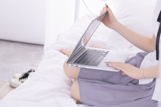 女孩在床上使用筆記本電腦