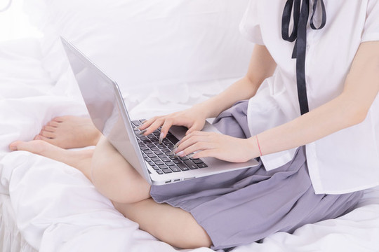 女孩在床上使用筆記本電腦