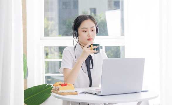 女性客服戴著耳麥?zhǔn)褂秒娔X