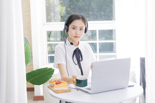 女性客服戴著耳麥使用電腦
