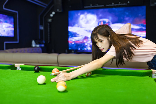 在娛樂房里打臺球的美麗女性