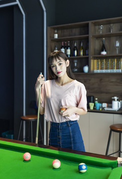 在娛樂(lè)房里打臺(tái)球的美麗女性
