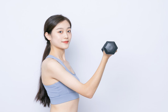 手持啞鈴運(yùn)動(dòng)的年輕女性