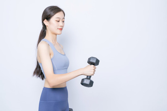 手持啞鈴健身的東方女性