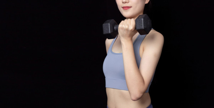 手持啞鈴健身的年輕女性