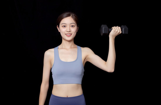 手持啞鈴健身的年輕女性