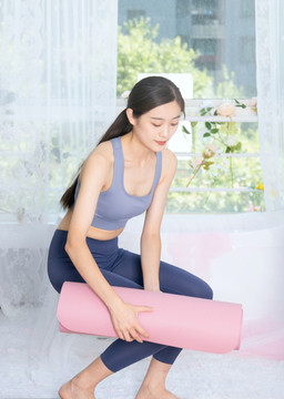 室內(nèi)女性整理瑜伽墊
